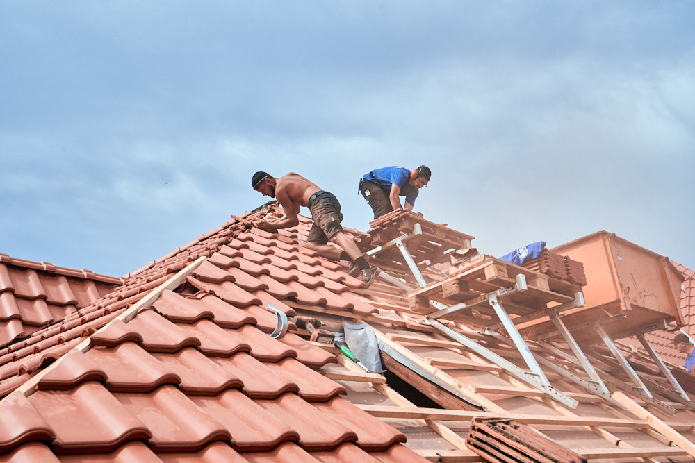 Kühne Meisterbetriebe, Dachdecker Handwerker arbeiten auf einem Dach in Kassel